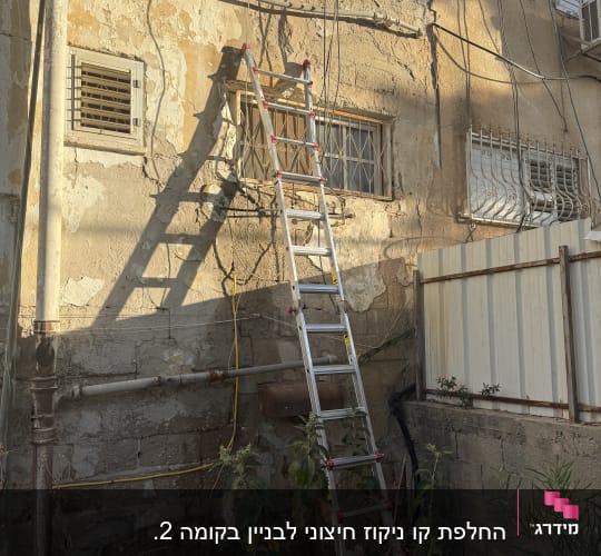 קיר חיצוני עם סולם וצינורות חשופים